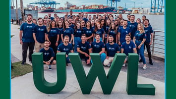 UWL do Brasil team gathers outside of the new office in Itajaí in front of the ports.